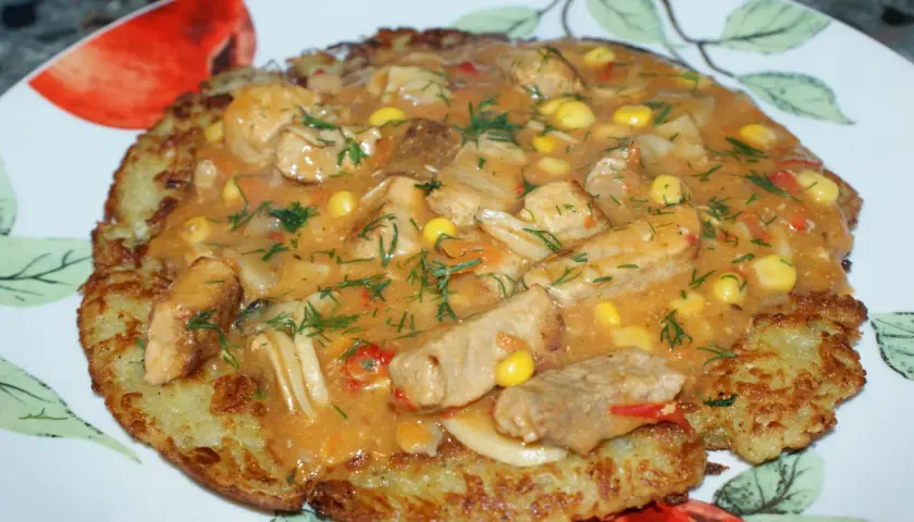 Pyszny placek po węgiersku z kawałkami mięsa, kukurydzą i aromatycznym sosem, posypany świeżym koperkiem.