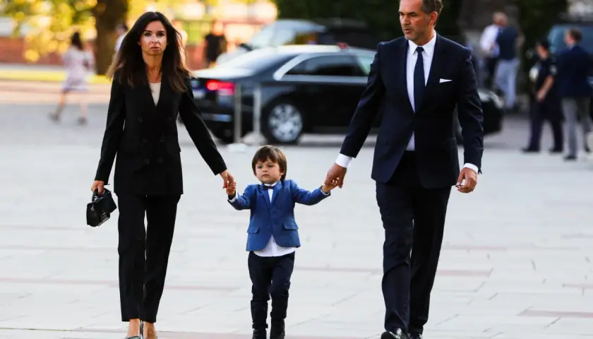 Marta Kaczyńska z mężem i synem w eleganckich strojach spacerują.