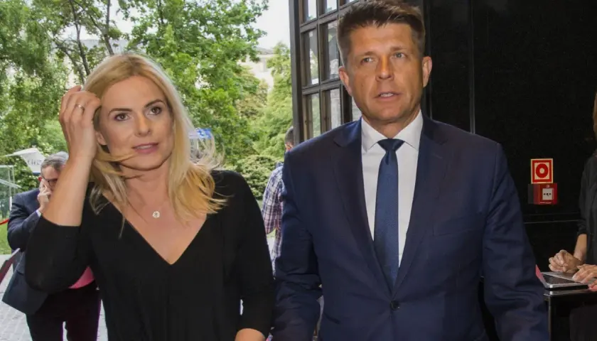Para, która może być odpowiedzią na pytanie, czy Ryszard Petru ma żonę, idzie obok siebie. Kobieta ma blond włosy i czarną bluzkę, mężczyzna w granatowym garniturze.
