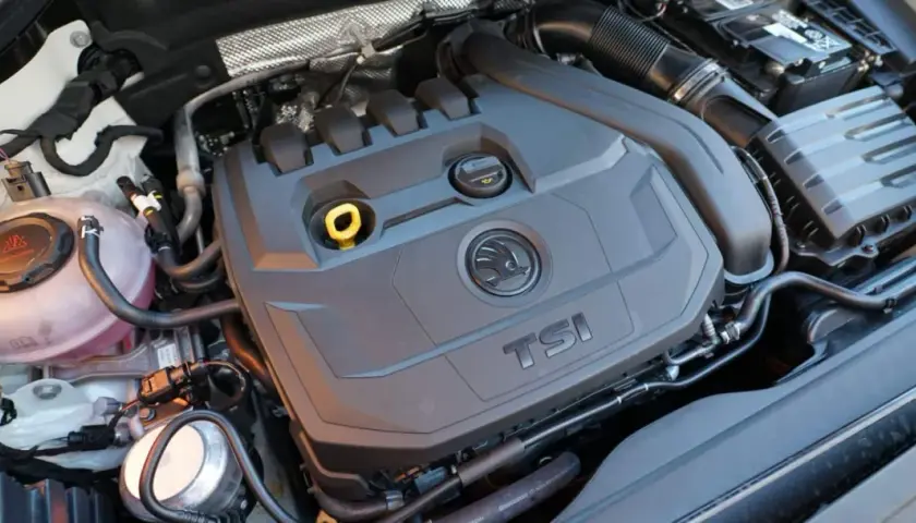 Motor 1.5 TSI 150cv, con su tapa negra y logo Skoda. Se aprecian manguitos y depósito de refrigerante.