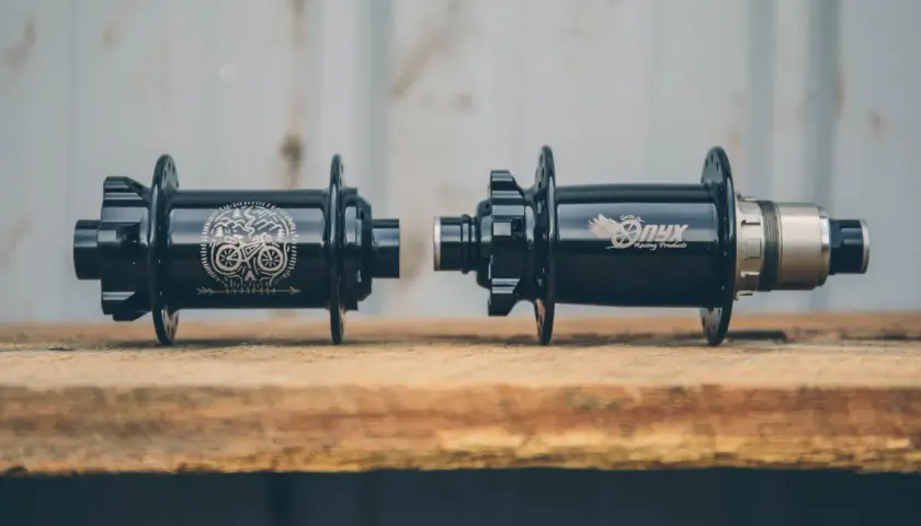 Two black Onyx Vesper hubs, one with a skull and bike graphic, the other with the Onyx logo, ready for a review.