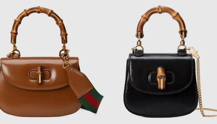 Dwie torebki Gucci z bambusowym uchwytem, symbolizujące bogatą historię rodziny Gucci. Brązowa z paskiem w paski, czarna z łańcuszkiem.