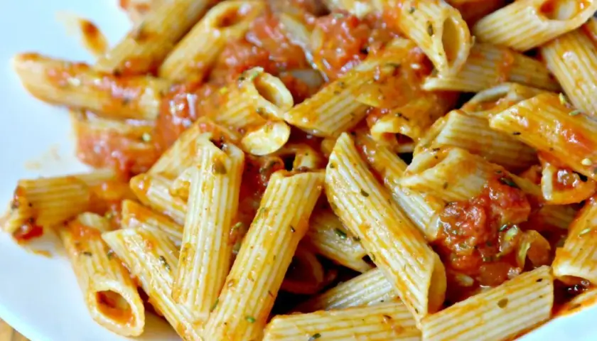 Pyszny makaron penne z aromatycznym sosem pomidorowym, posypany ziołami. Idealny na szybki obiad.