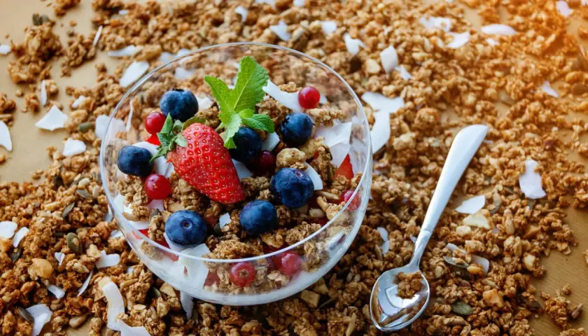 Knuspriges Granola mit Beeren und Kokosflocken in einer Schale. Was ist Granola? Ein leckeres Frühstück!