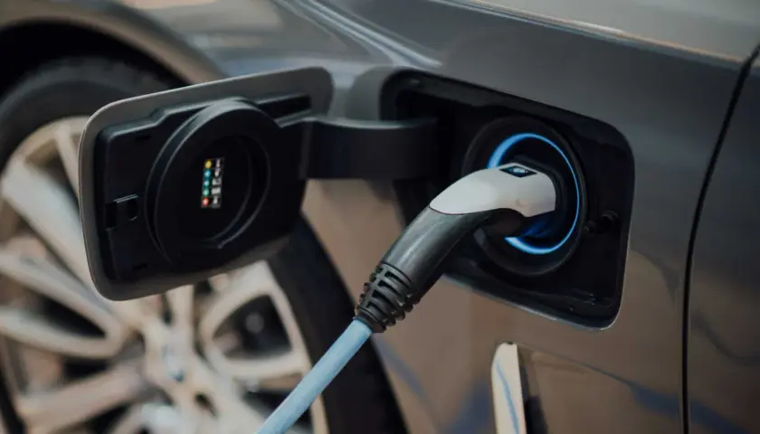 Prise de recharge d'une voiture électrique, le câble bleu est branché, prêt à alimenter les batteries.