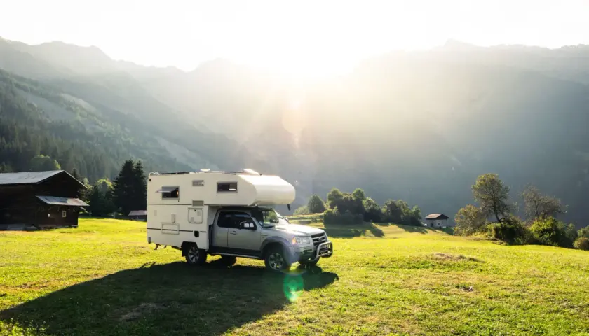 Camping-car dans un paysage montagneux ensoleillé, un endroit idéal pour le meilleur pays pour voyager en van.
