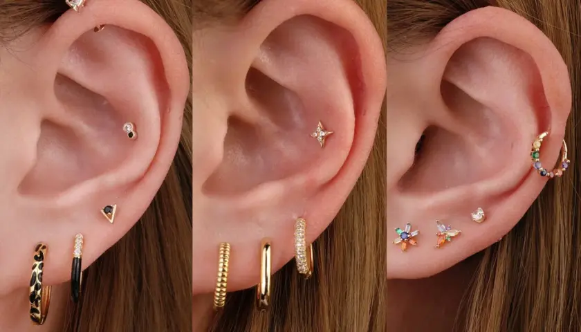 Ucho z kilkoma kolczykami, w tym błyszczącym helix piercingiem, gwiazdką i kolorowymi kamieniami.