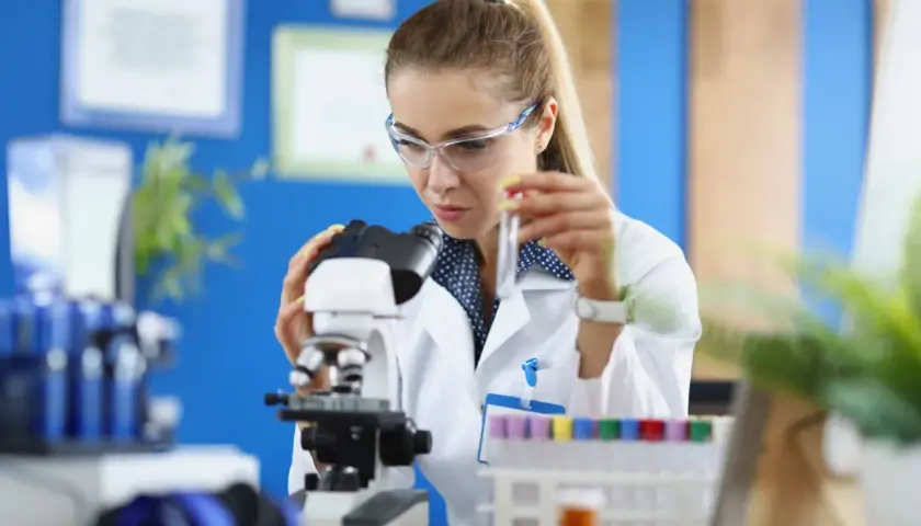 Studentka na biotechnologia studia bada próbkę pod mikroskopem.