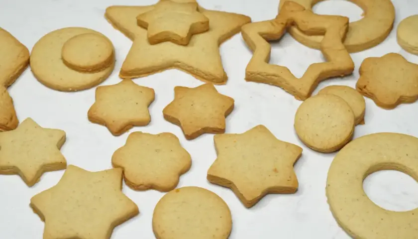 Variedad de galletas caseras horneadas con formas de estrellas, círculos y un anillo.