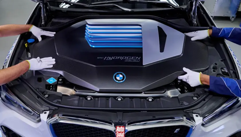 Ręce w białych rękawiczkach montują osłonę silnika BMW i Hydrogen Fuel Cell.