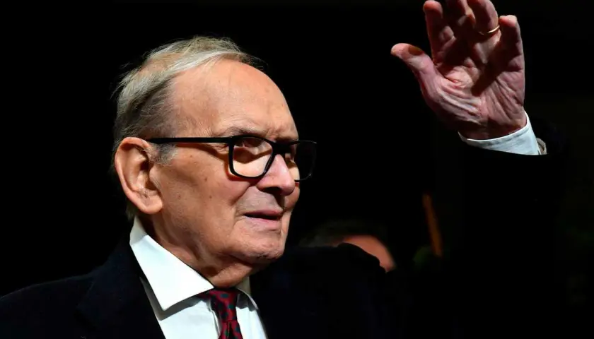 Ennio Morricone, kompositören bakom ikoniska filmer, vinkar med en ring på fingret.