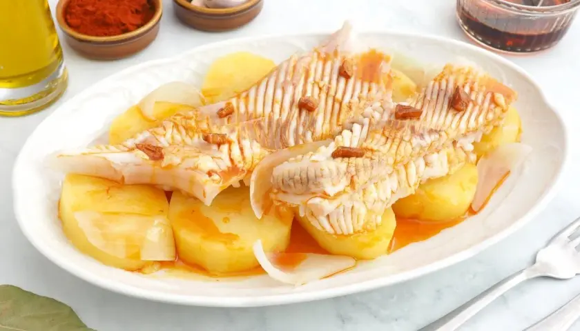 Raya a la gallega servida con patatas y cebolla, aderezada con aceite, pimentón y ajo.