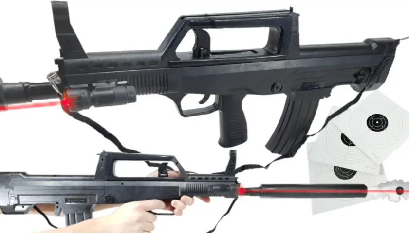 Dwa repliki karabinów ASG typu FAMAS z celowniczymi laserami i tarczami strzelniczymi.