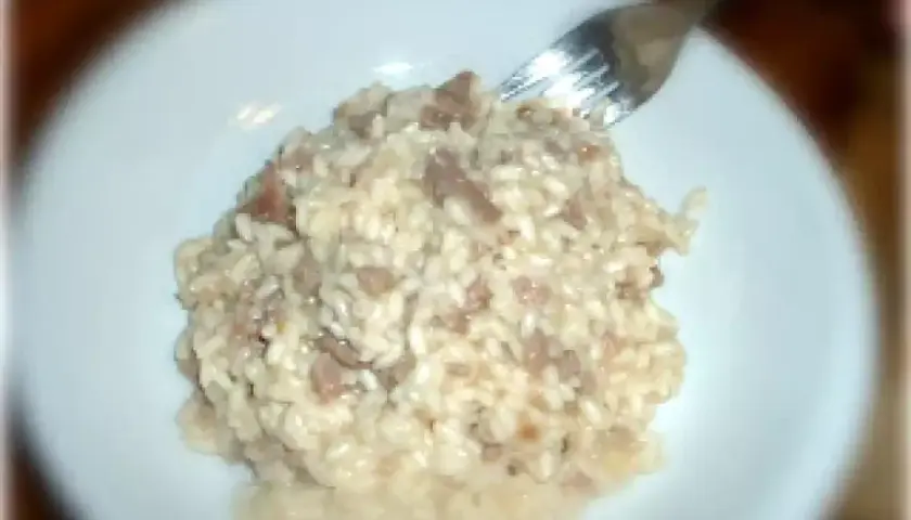 Un cremoso risotto con pasta di salame, pronto per essere gustato.