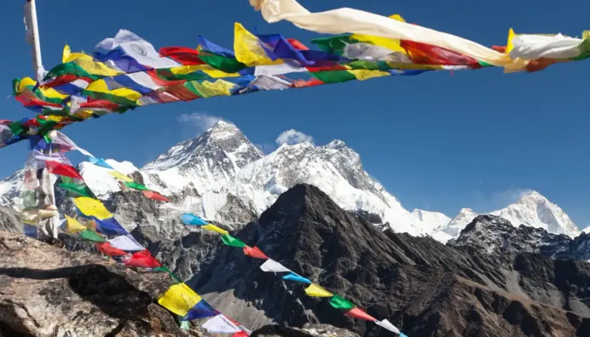 Modlitewne flagi powiewają na tle majestatycznego Everestu, który jest najwyższym szczytem na świecie.