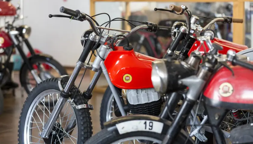Motocicletas clásicas rojas, algunas con el número 19, que se consideran un ciclomotor.