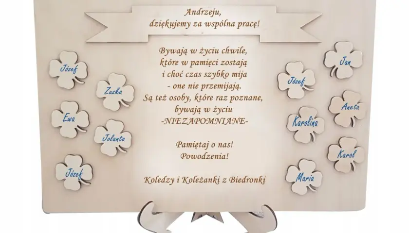 Drewniana tablica z podziękowaniami dla Andrzeja od kolegów z Biedronki. Na tablicy wypisane są słowa podziękowania i imiona: Józef, Zuzka, Ewa, Jolanta, Jan, Aneta, Karolina, Karol, Maria.