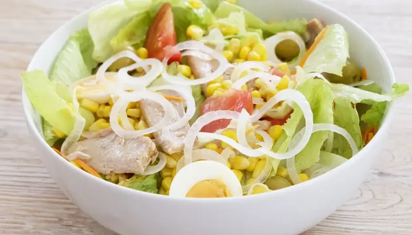 Deliciosa ensalada mixta con atún, huevo duro, maíz, tomate y cebolla. Fresca y completa.