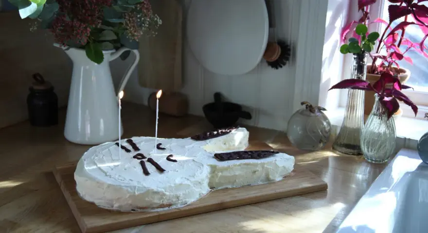 En gitarrformad tårta med vit frosting och chokladdekorationer, perfekt för alla musikälskare. En av många tårt ideer för en speciell dag.