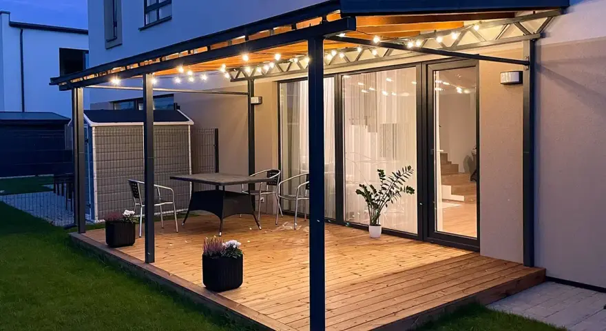 En mysig altan med pergola och ljusslingor. Perfekt för sommarkvällar, kanske efter att ha fått pergola bygglov.
