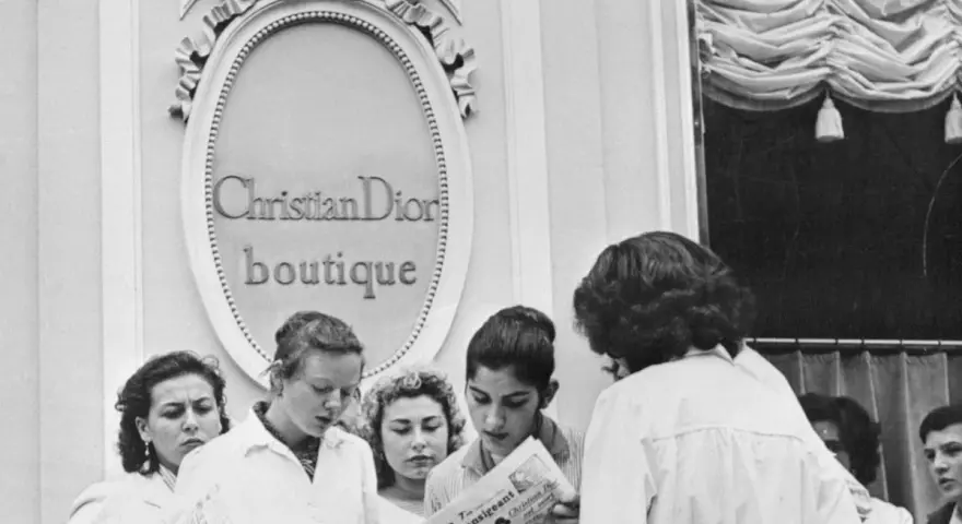 Donne leggono un giornale davanti alla boutique Christian Dior, dove nasce la moda.