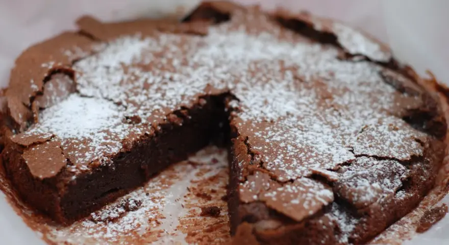 En saftig kladdkaka, pudrad med florsocker, redo att avnjutas. Perfekt för fikat eller som en del av ett dessertbord med andra kladdkaka kakor.