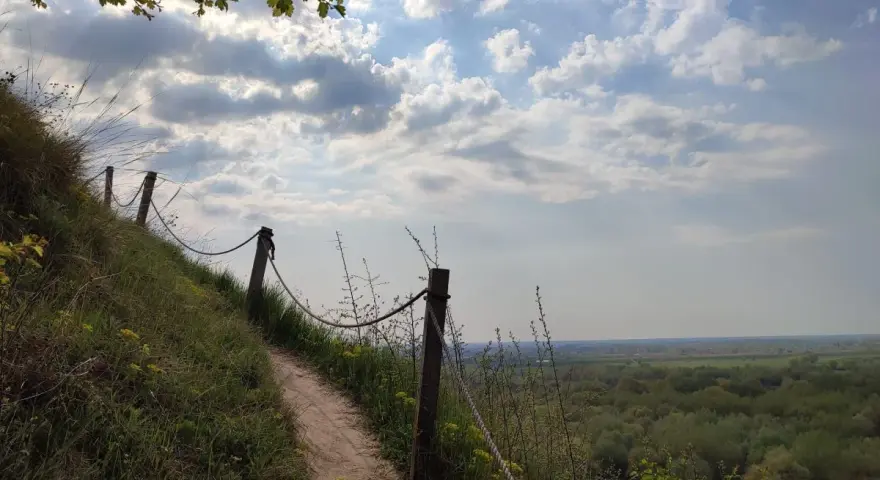 Ścieżka na zboczu Góry Pieprzowe. W oddali rozciąga się zielona dolina.