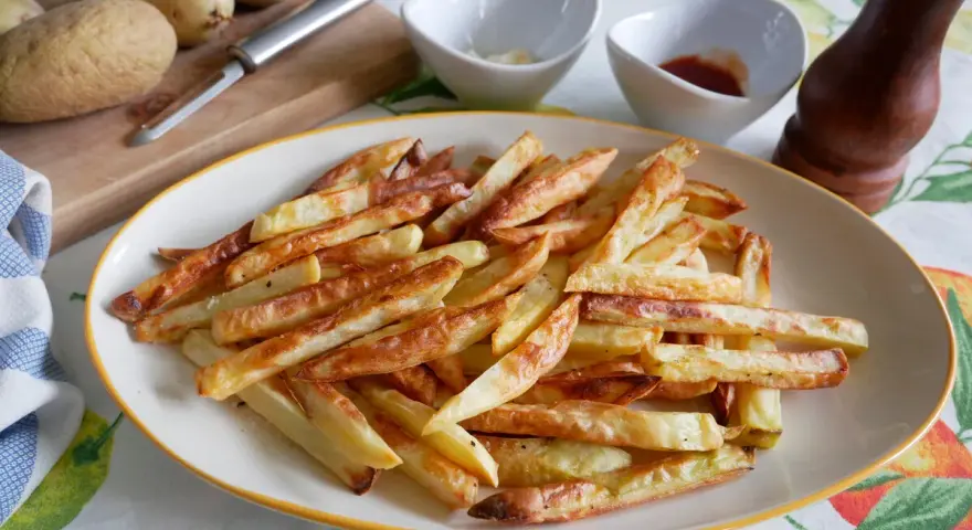 Patatas fritas doradas y crujientes, recién salidas de la freidora de aire. Perfectas para acompañar cualquier comida.