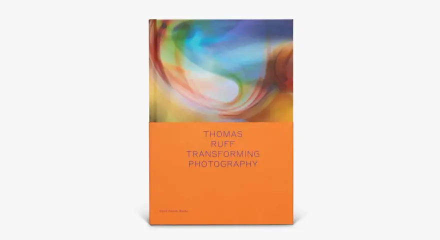 Okładka książki "Thomas Ruff: Transforming Photography" z abstrakcyjnym, kolorowym wzorem i pomarańczowym spodem.