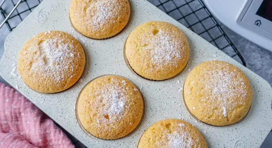 Sechs goldbraune Muffins, mit Puderzucker bestäubt, warten auf ihre Verkostung. Perfekt aus dem Thermomix!