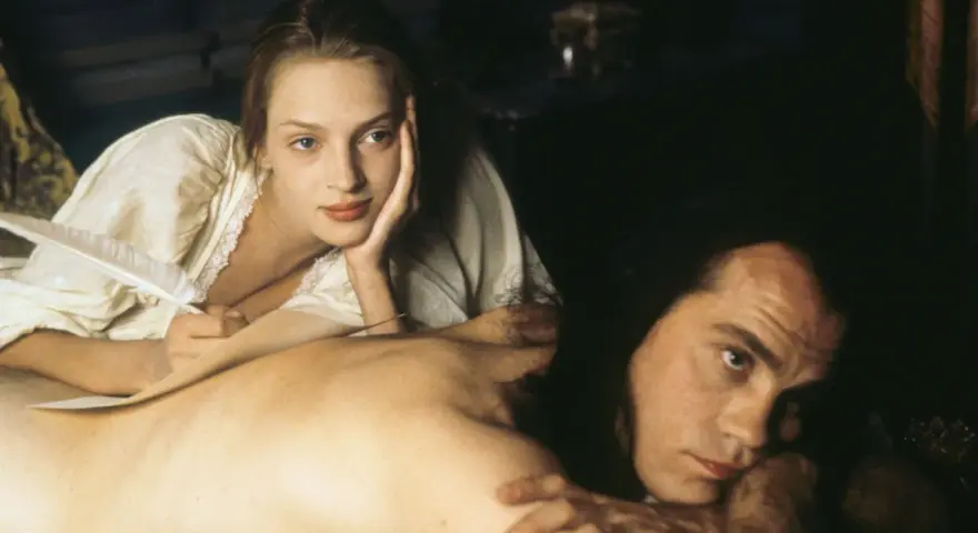 Coppia in un momento intimo, evocativo di scene da film erotici. Lei scrive con una penna d'oca, lui la guarda intensamente.