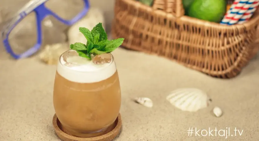 Orzeźwiający vodka sour z miętą na plaży, obok maska do nurkowania i koszyk z limonkami. Idealny na wakacje!