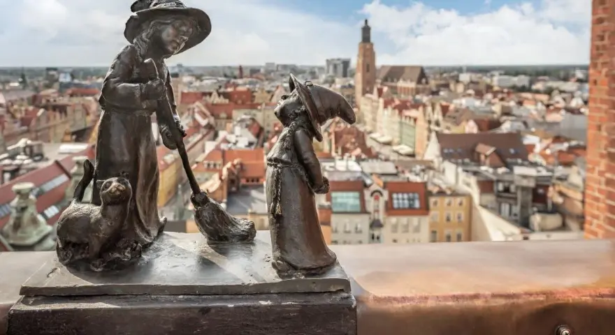 Dwa krasnale i kot na tle Wrocławia. Zastanawiasz się, ile jest krasnali we Wrocławiu?