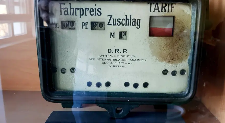 Altes Taxameter mit "Fahrpreis" und "Zuschlag" Anzeige. Der Tarif ist auf 0,90 Mark eingestellt.