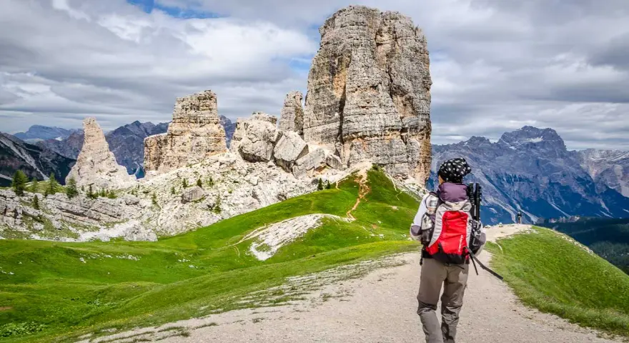 Wanderer auf einer **Cinque Torri Wanderung** mit Blick auf die markanten Felsformationen und die Dolomiten.