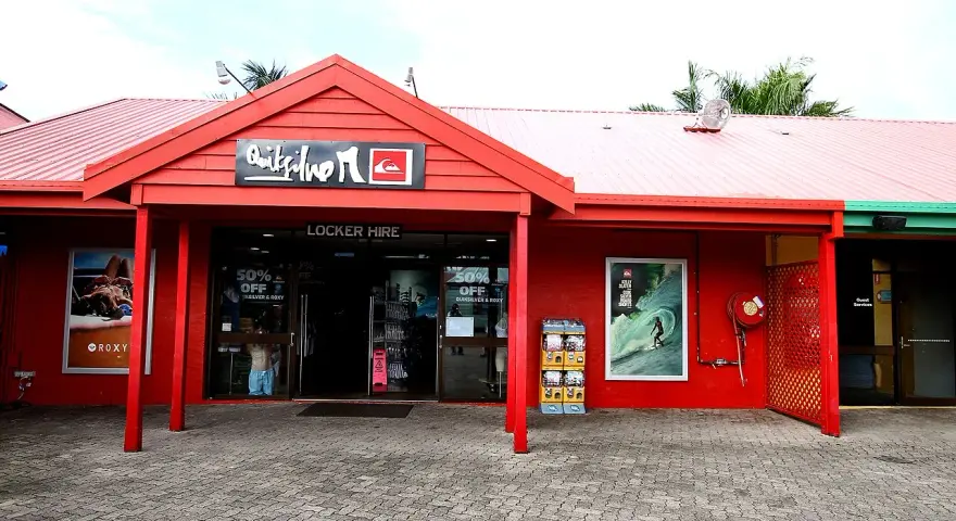Sklep Quiksilver, znanej firmy odzieżowej dla surferów, z czerwonym logo i ofertą "Locker Hire".