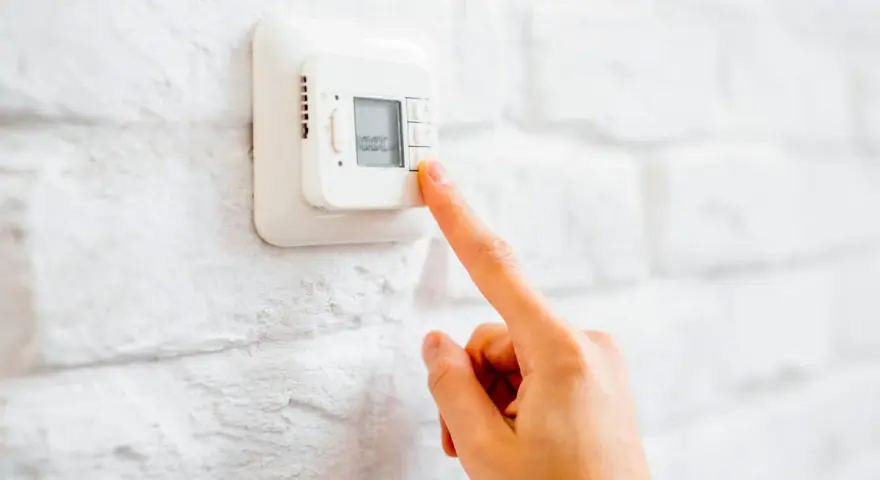 Ajustando el termostato para unos agradables grados calefaccion invierno.