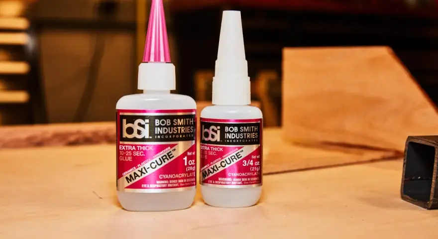 Two bottles of Bob Smith Industries Maxi-Cure glue, explaining why super glue is so strong due to its cyanoacrylate formula.