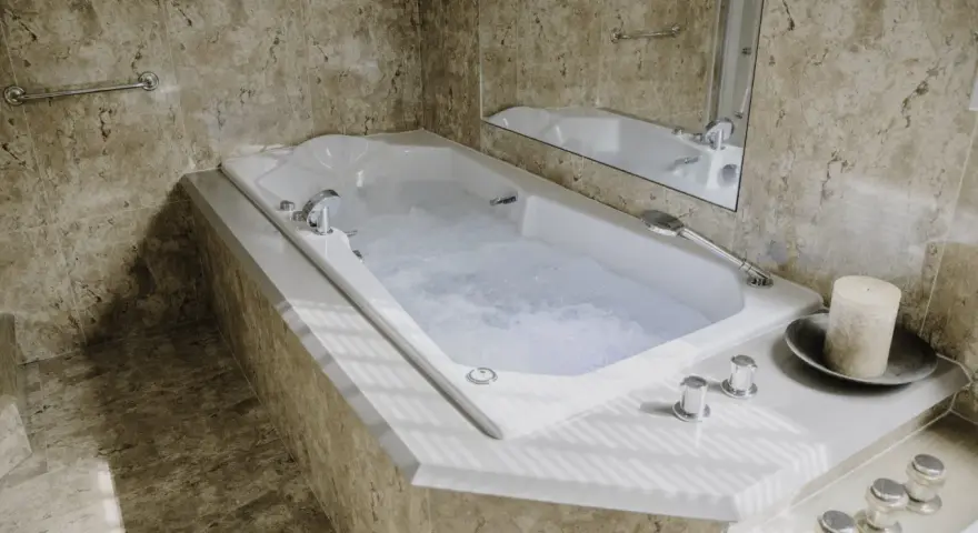 Baignoire balnéo avec jets d'eau bouillonnante, ambiance spa relaxante. Avis positif pour ce moment de détente.