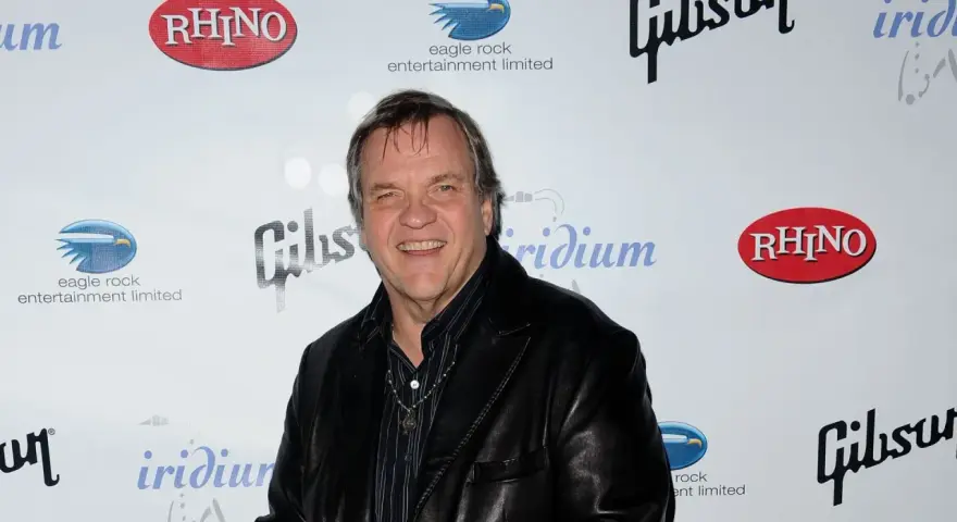 Meat Loaf lächelt in die Kamera, bereit, alles für die Liebe zu tun. Hinter ihm sind Logos von Rhino, Gibson und Eagle Rock Entertainment zu sehen.
