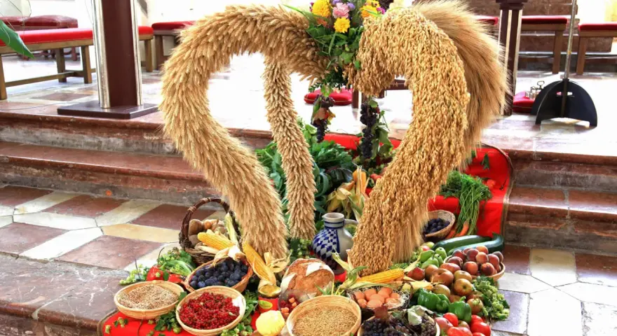 Erntedankfest: Herz aus Getreide mit Früchten, Gemüse und Brot.