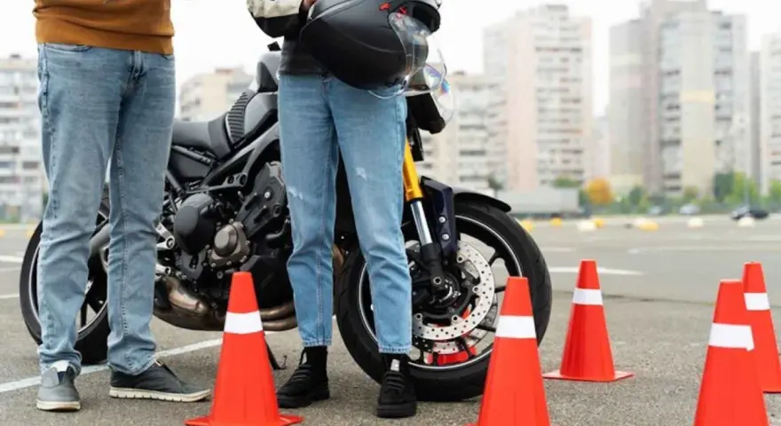 Instructor y alumno junto a moto en circuito de prácticas. Se preguntan: ¿cuánto dura el teórico del A2?