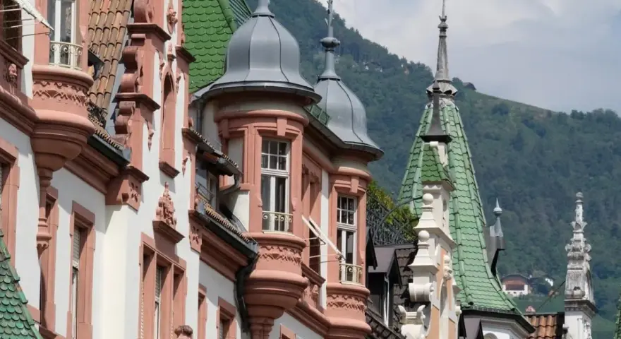 Edifici storici con tetti verdi e torrette a Bolzano, un assaggio di **Bolzano in un giorno**.