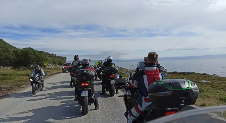Motocykliści jadący w kierunku Nordkapp w Norwegii, podziwiając malownicze krajobrazy wybrzeża.