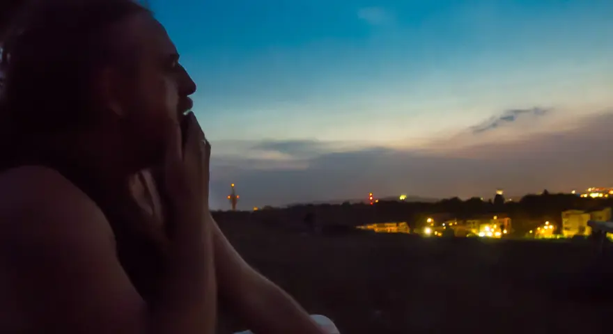 Mężczyzna zamyślony patrzy na nocne miasto. Odeszłam, ale tęsknię za tym widokiem.
