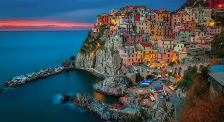 Kolorowe domy Cinque Terre na klifie nad morzem. Idealne miejsce, jeśli zastanawiasz się, **włochy gdzie jechać**.
