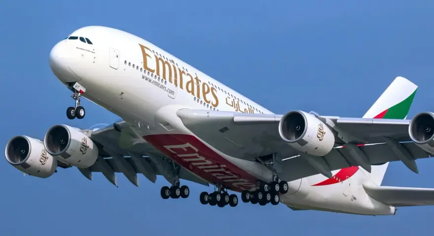Airbus A380 Emirates z wieloma miejscami, wznoszący się na błękitne niebo.