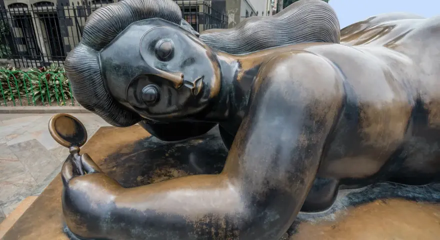 Sculpture d'une femme en bronze, tenant un miroir, évoquant les sculpteurs français contemporains connus.