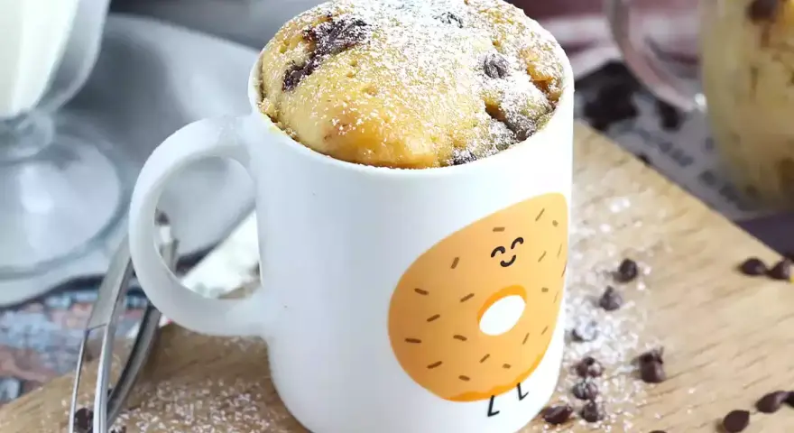Delicioso bizcocho a la taza con chispas de chocolate, espolvoreado con azúcar glas. ¡Perfecto para un antojo rápido!