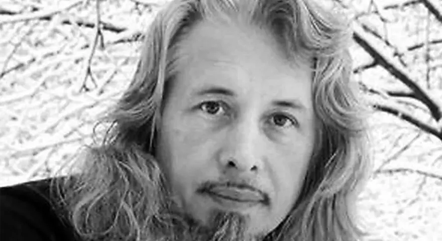 Vladimir Sorokin, med sitt långa hår och skägg, blickar ut mot en snötäckt vinterbakgrund.